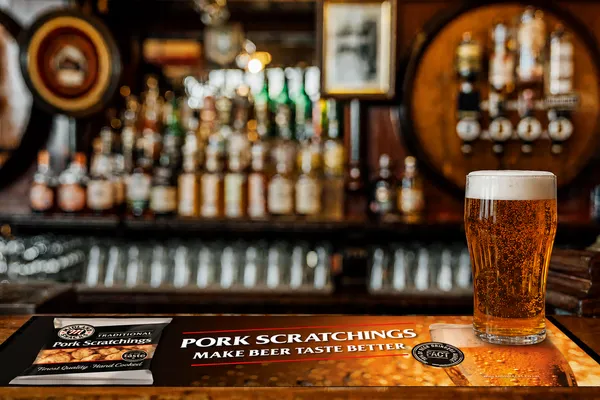 Midland Snacks 'Pork Scratchings Make Beer Taste Better' bar runner on a pub bar